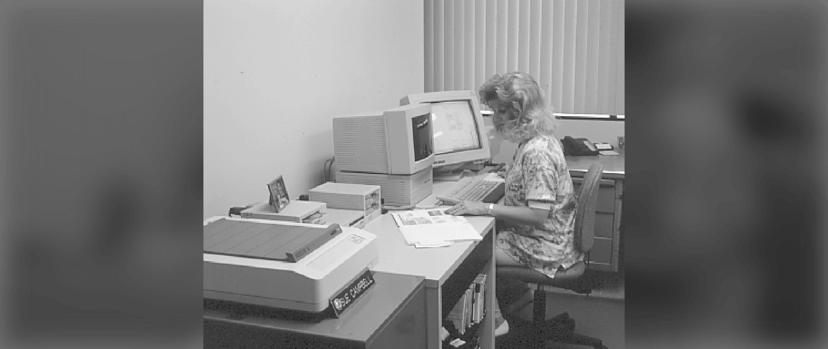 Black and white photo of a woman working on a computer