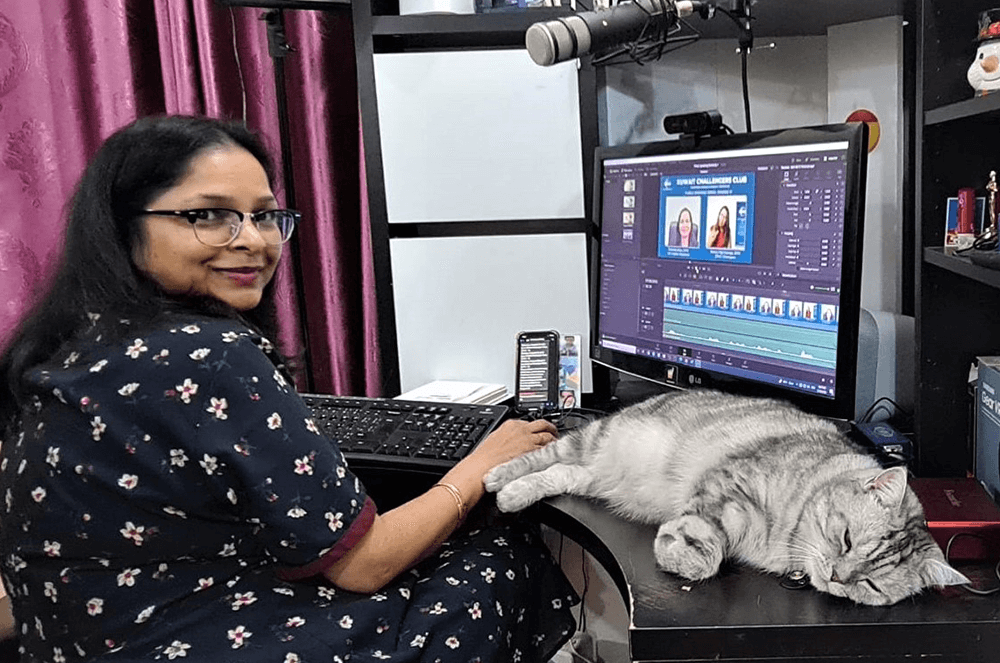 Woman sitting at computer with cat