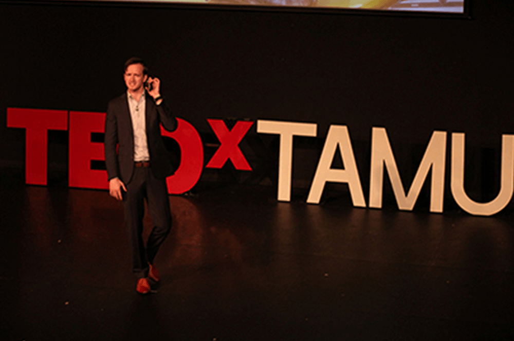 Man speaking on TEDx stage 