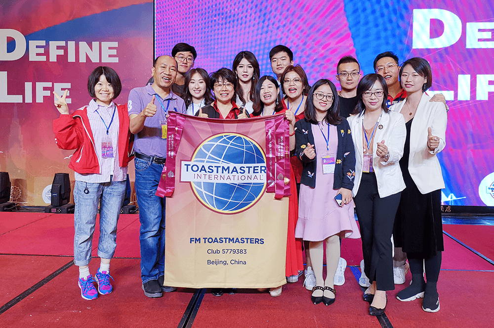 Group of people posing with banner