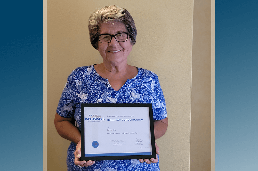 Woman in blue shirt holding framed certificate