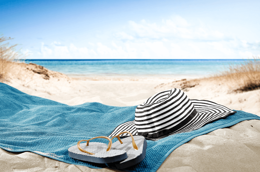 Hat and flip flops on beach towel