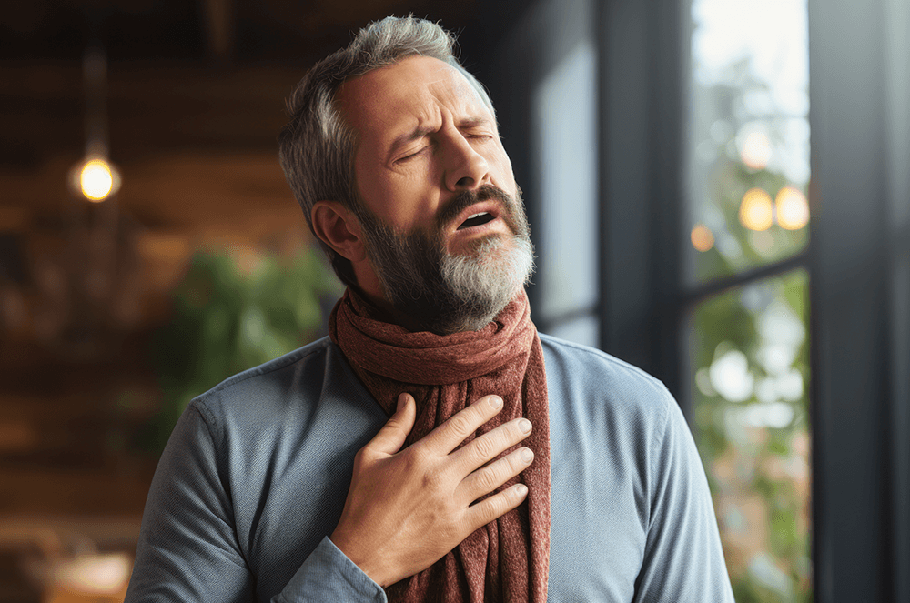 Man wearing a scarf holding his chest with eyes closed trying to speak