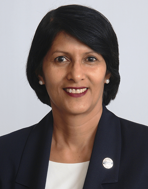 Woman smiling in suit jacket with pin