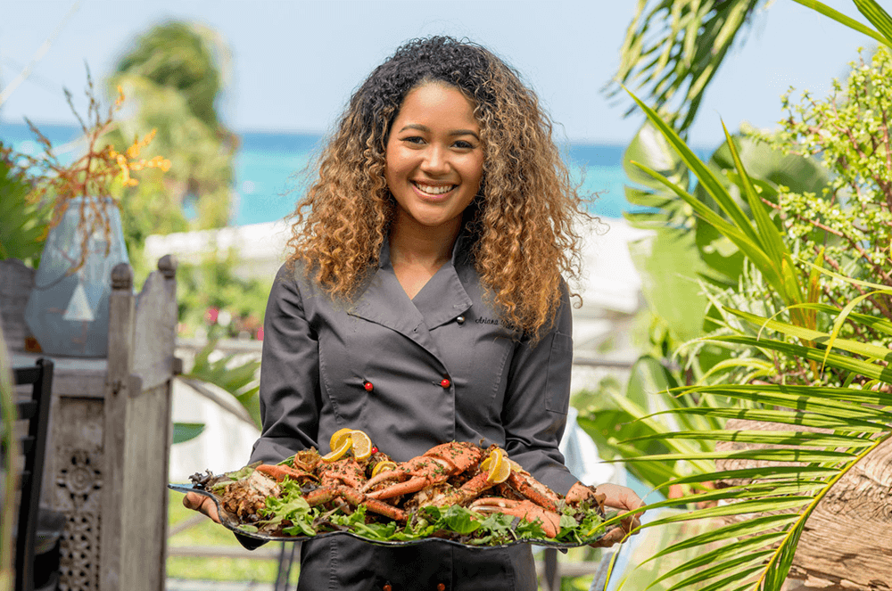 Woman holding plate of crab legs in The Bahamas