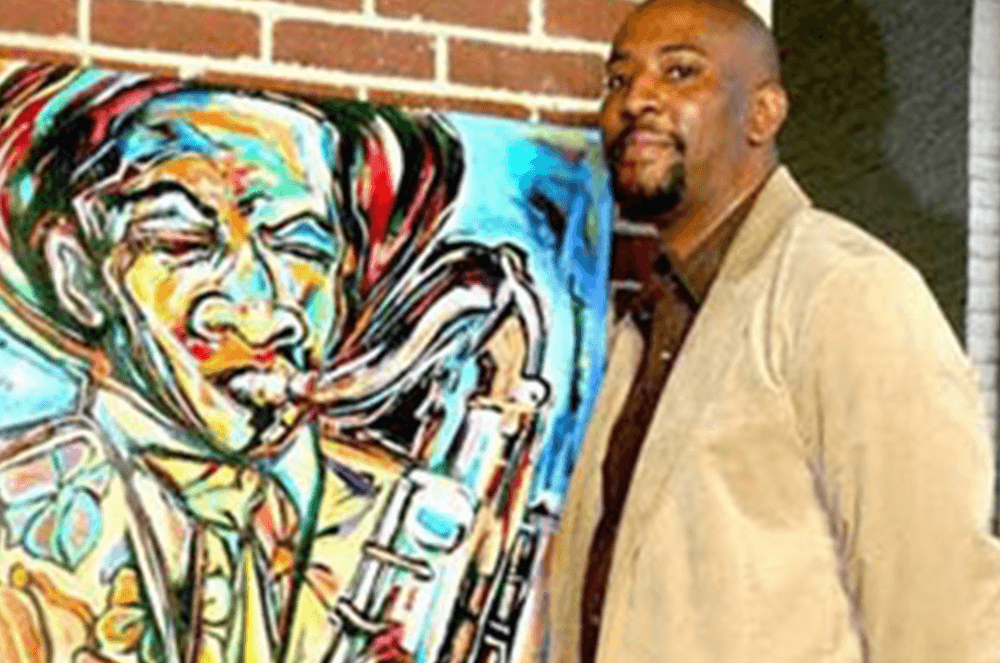 Man standing next to painting of legendary saxophonist Charlie Parker
